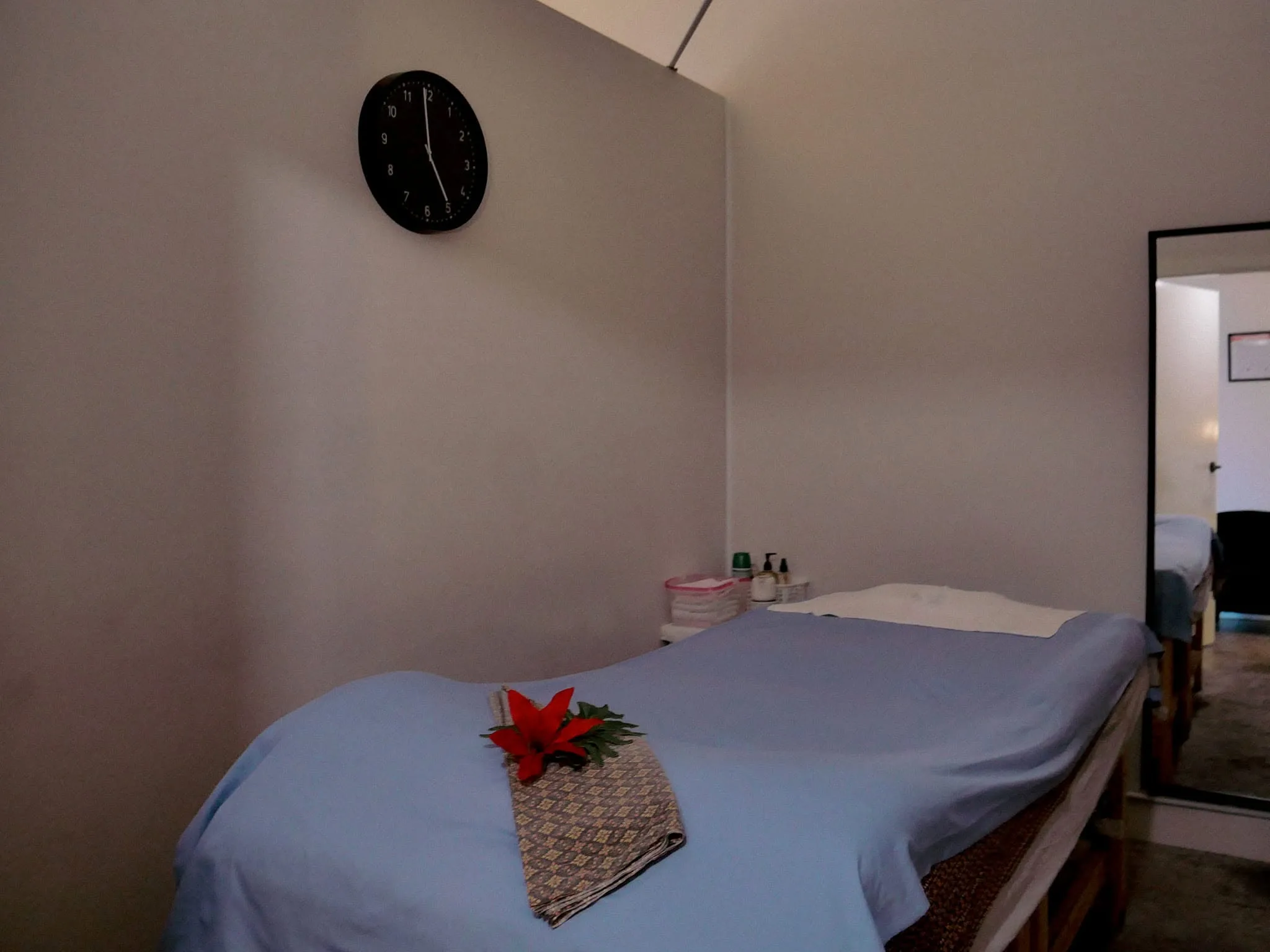 Ladda Thai Massage treatment room with salt-lamp-lit brick nook, tall mirror and lilac linen